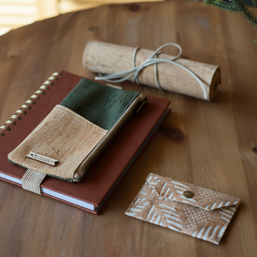 Notebook with leather cover, wrapped gift, and decorative items on a wooden surface